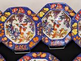six blue and orange plates with flowers and butterflies on them