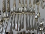 a lot of silver spoons and forks on the table