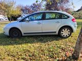 a silver car parked in the grass next to a tree