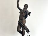 statue en bronze représentant une femme tenant un oiseau, posée sur un socle noir