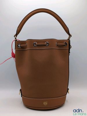 un sac à main en cuir marron avec une poignée rouge sur fond blanc