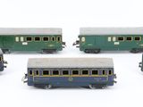 five toy trains on a white surface one is blue and the other is green