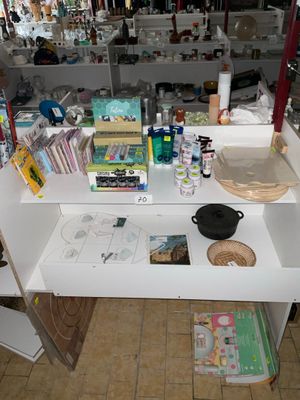 une table blanche sur laquelle sont posés de nombreux objets, dans une pièce
