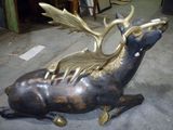 une statue de cerf assise sur le sol