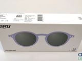 L'étui d'une paire de lunettes de soleil est posé sur une surface blanche