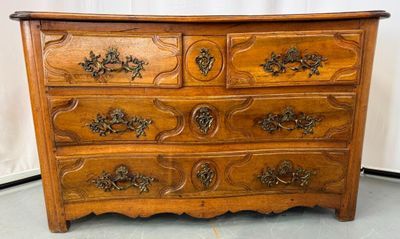 Commode en bois naturel à façades galbées.