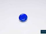 a blue sapphire stone on a white surface