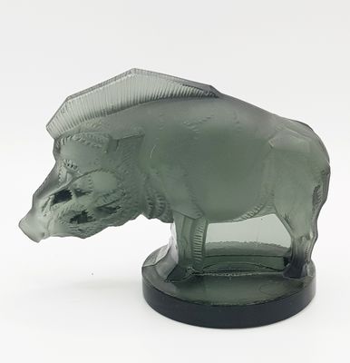 a glass figurine of a boar on a black base