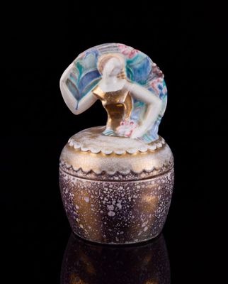 une boîte en verre surmontée d'une figurine