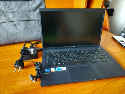 un ordinateur portable posé sur une table avec un chargeur