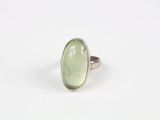 une bague sertie d'une pierre verte sur un fond blanc