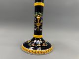 une image représentant un vase noir et jaune orné de fleurs