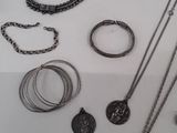many different types of necklaces and bracelets on the table