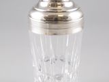 shaker à cocktail plaqué argent avec un verre en cristal sur fond blanc