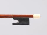 un archet de violon avec un manche en bois et une pointe blanche