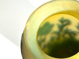 a yellow vase that has a picture of a tree on it