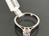 a close up of a diamond ring on a table with a price tag