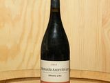 une bouteille de vin posée sur un tonneau en bois