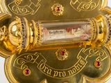 a gold clock that is on display on a table