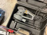 a tool in a case with a corded sander