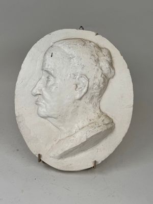 white plaster portrait of a man in profile on a white background