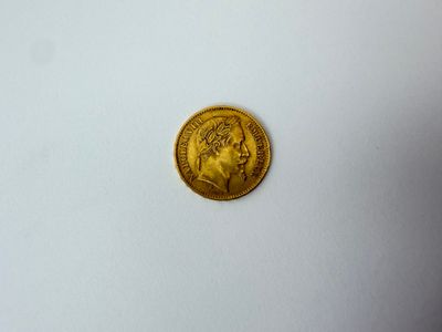 gros plan d'une pièce d'or sur une surface blanche