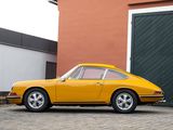 yellow porsche 911 parked in front of a building with a garage behind it