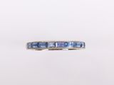 un gros plan d'une bague sertie de saphirs bleus sur fond blanc