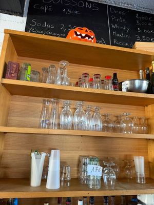 a shelf with many glasses and bottles on it