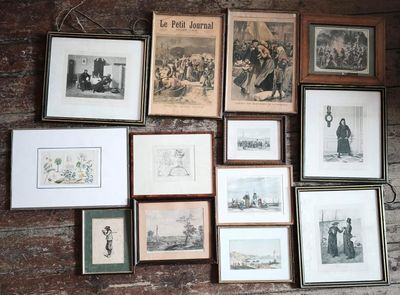 many framed pictures on the wall of this room