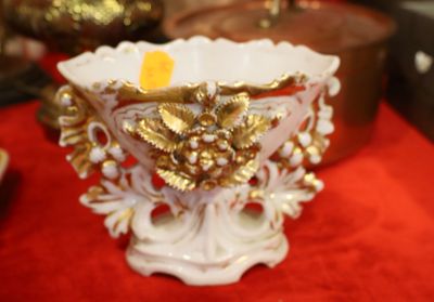 un vase blanc et doré posé sur une table rouge