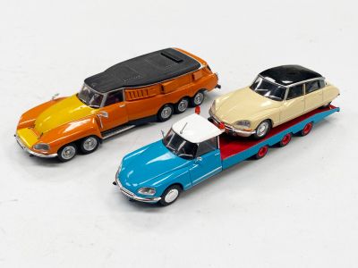 trois petites voitures qui se trouvent sur une remorque à plateau