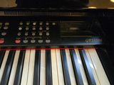 a black piano with white and red keys sitting on a table