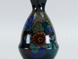 un vase noir orné d'un motif floral