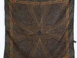 une écharpe à motifs paisley marron et bleus accrochée à un mur