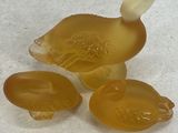 three glass ducks sitting on a white surface