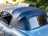 a blue car with a black top parked on the side of the road