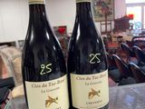 two bottles of wine sitting on a table in a restaurant