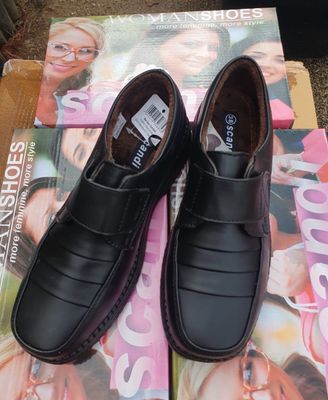 une paire de chaussures noires pour homme posée sur un magazine