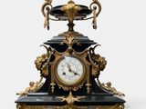 a black and gold clock sitting on top of a table