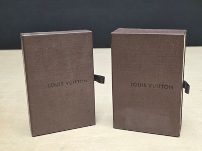deux livres Louis Vuitton posés sur une table en bois