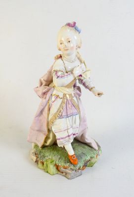 a figurine of a woman in a dress and hat