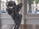 a statue of a little angel on a rock on a table