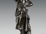 une statue en bronze représentant une femme tenant un panier de fleurs