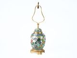 a lamp that is sitting on a stand with a bird on it