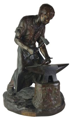 bronze statue of a blacksmith with a hammer and an anvil