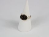 bague en argent ornée d'une pierre marron posée sur un cône blanc