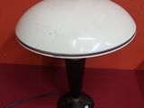 une lampe de table blanche posée sur une table près d'un mur rouge