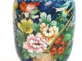 a colorful vase with flowers on it on a table