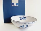 a blue and white bowl sitting next to a blue and white box
